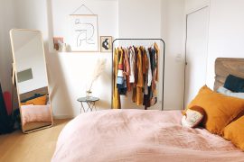 chambre avec penderie sur roulettes et miroir en pied dans un coin