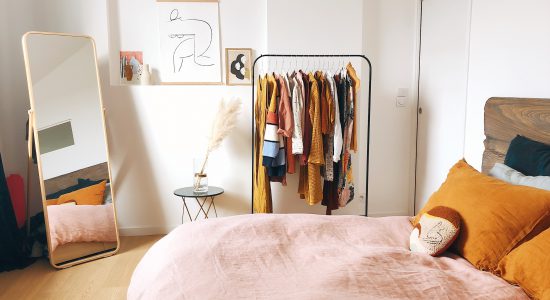 chambre avec penderie sur roulettes et miroir en pied dans un coin